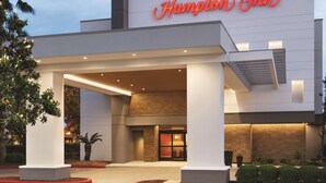 A modern hotel entrance with a prominent sign reading "Hampton Inn." - Hampton Inn Houston-Brookhollow (Houston)