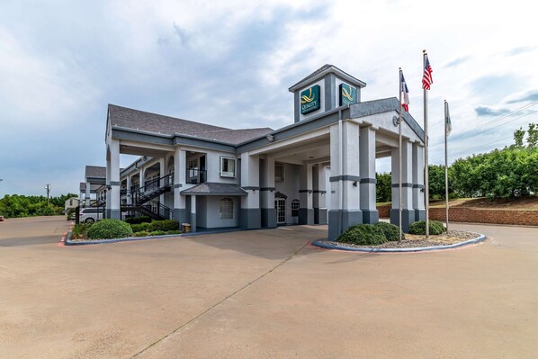 Quality Inn Express features a modern architectural design with a flat roof and symmetrical facade, surrounded by a well-maintained landscaped area.