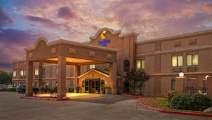 A Comfort Inn hotel with a classic architectural style, a well-lit entrance, and a parking lot. - Comfort Inn North Conroe (Conroe)