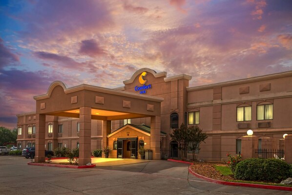 A Comfort Inn hotel with a classic architectural style, a well-lit entrance, and a parking lot.