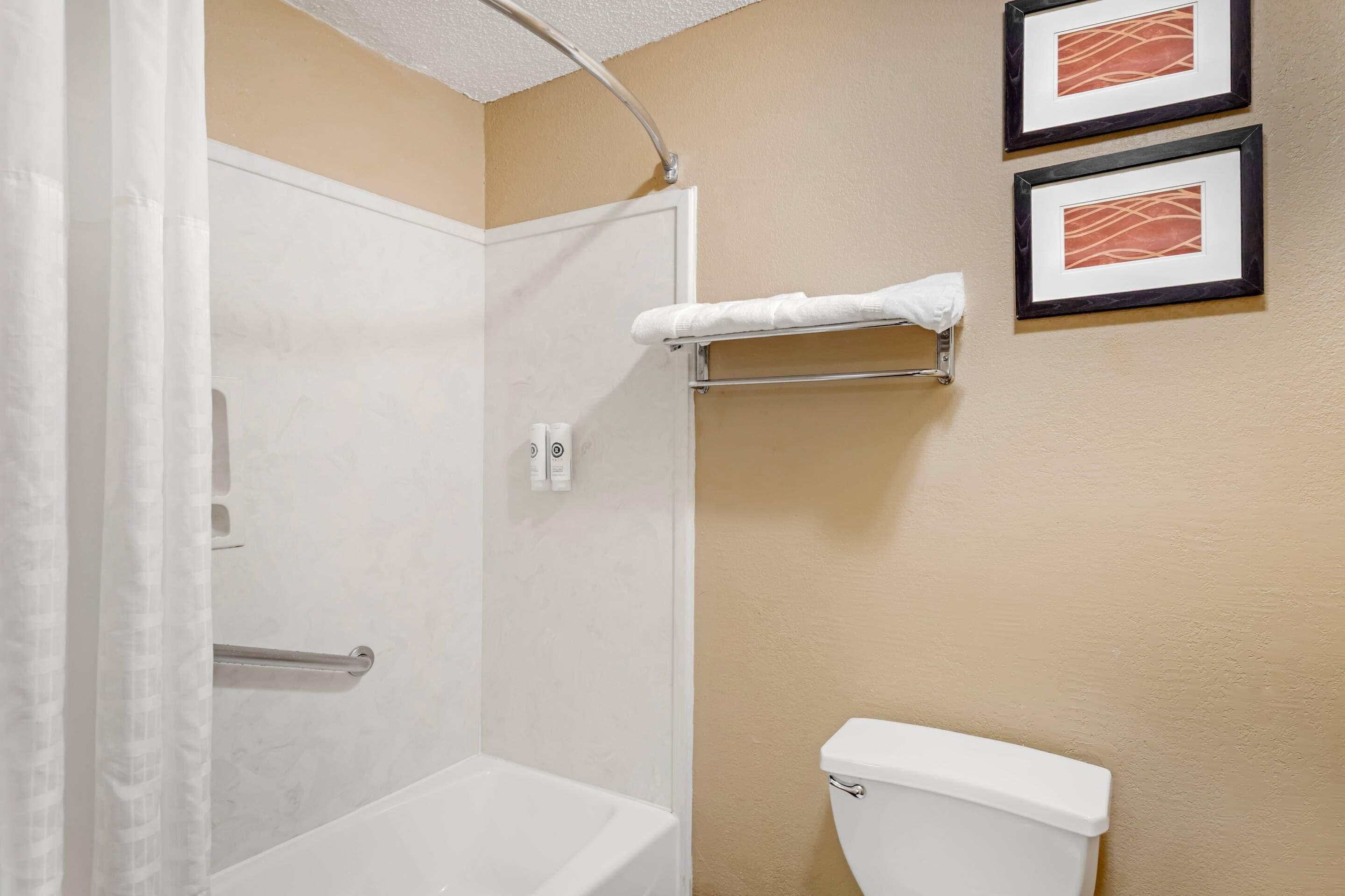Ein Badezimmer mit Dusche, Toilette und Handtuchhalter.