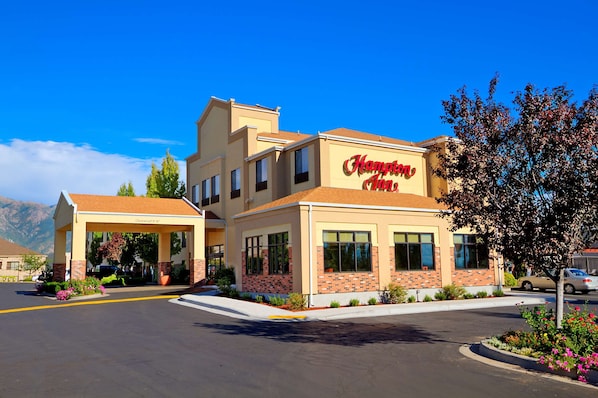 A Hampton Inn hotel with a two-story structure, a covered entrance, and a parking lot.