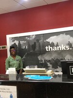 Una mesa de recepción con un cartel que dice 'gracias' y otro que dice 'gracias por practicar', además de un cuadro con un paisaje montañoso.
