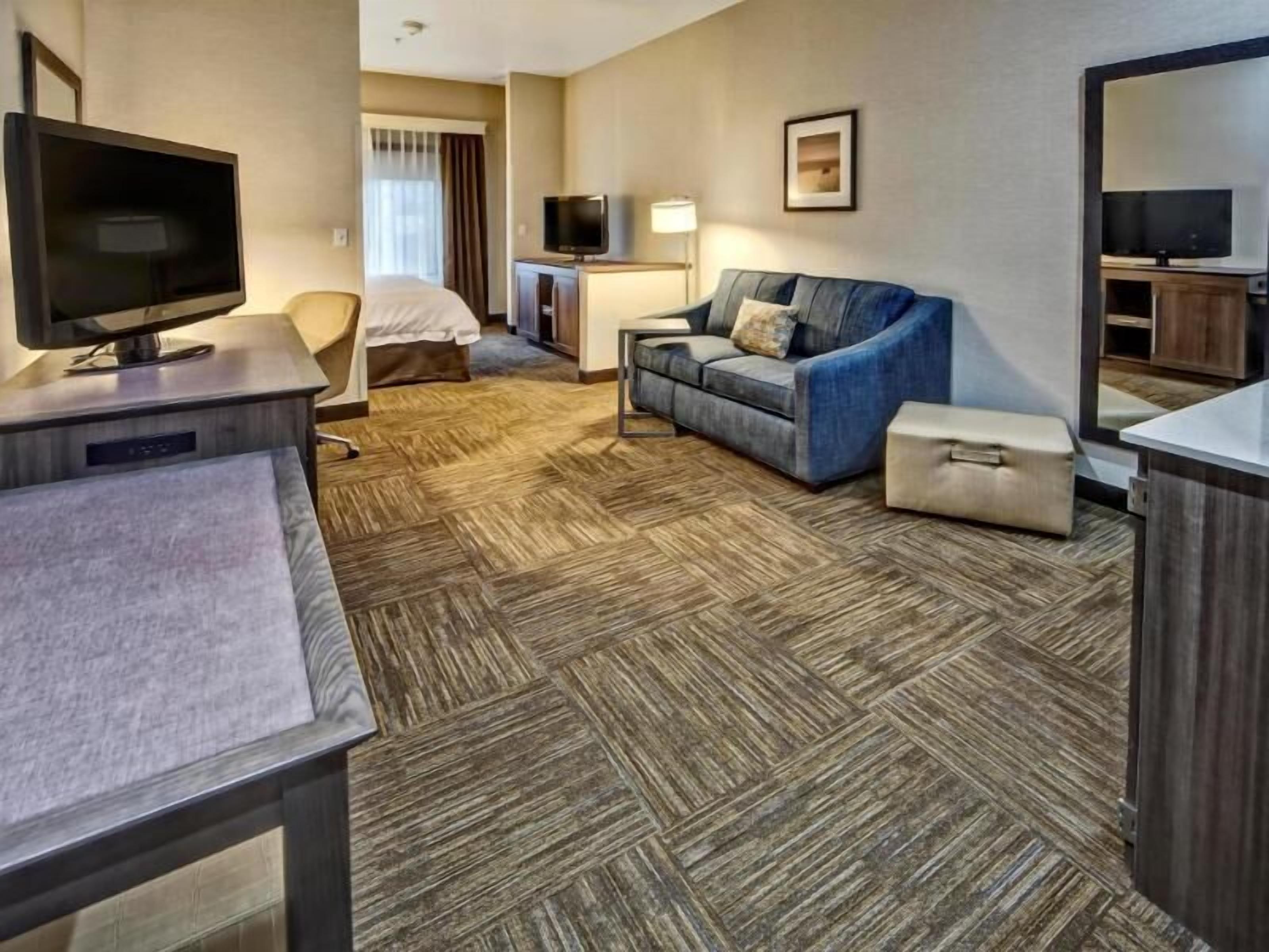 أغطية فراش متميزة وخزنة داخل الغرفة ومكتب ومساحة عمل للكمبيوتر المحمول