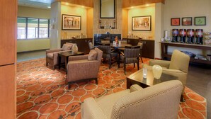 A spacious lobby with a patterned carpet, comfortable seating, a coffee bar, and artwork on the walls. - Hampton Inn Salt Lake City/Layton (Layton)