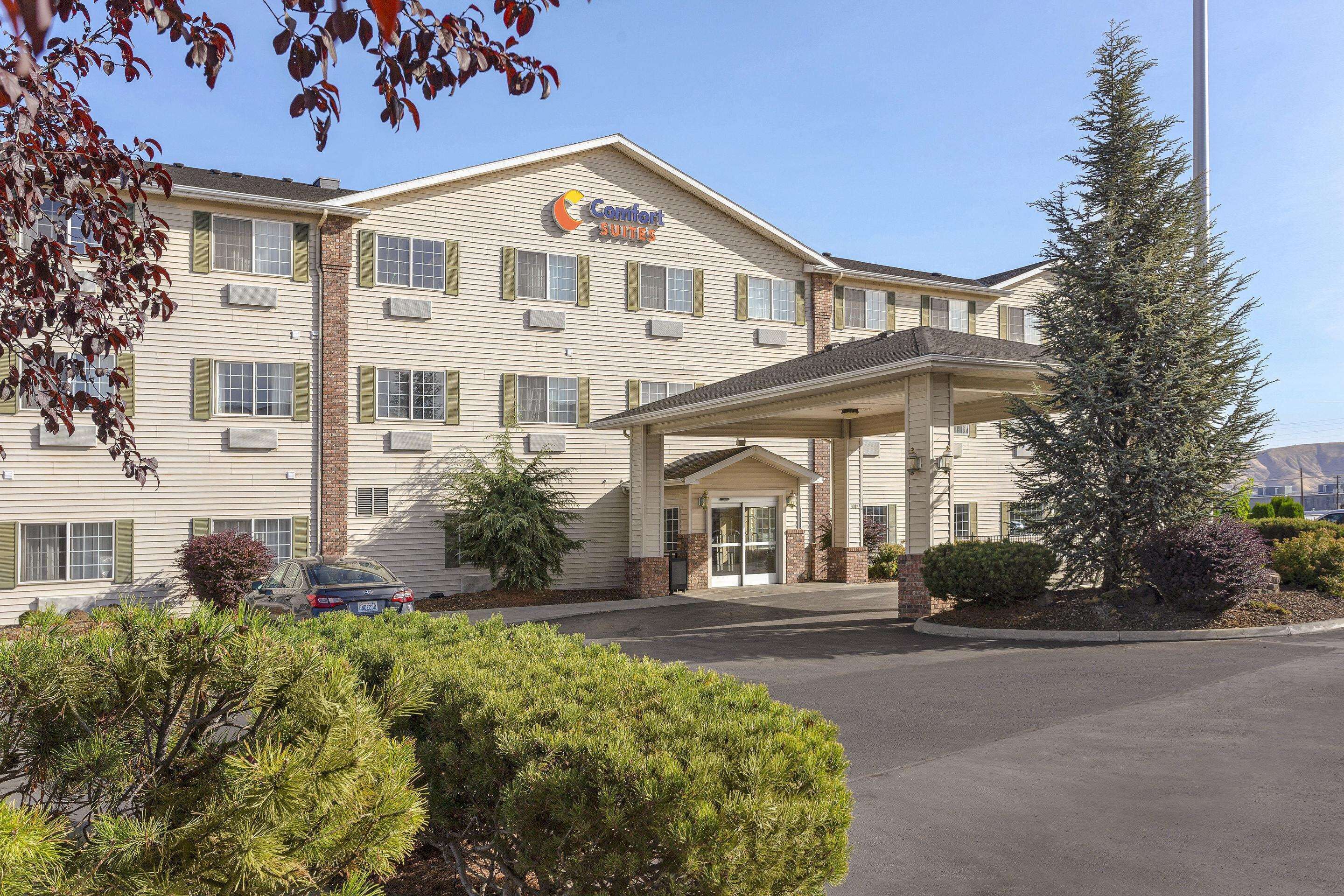 A Comfort Suites hotel with a covered entrance, multiple windows, and a parking lot.