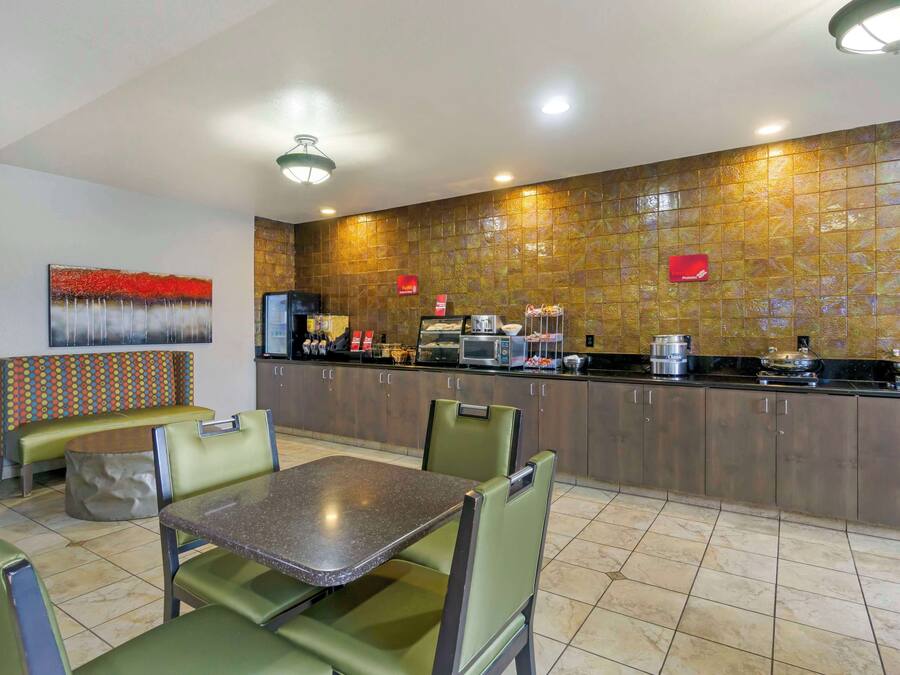 A restaurant with a counter, seating area, and a wall with a textured design.