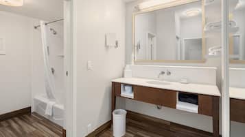 A modern bathroom with a shower, a sink, and a mirror.