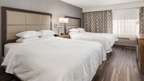 A hotel room with two beds, a nightstand, a lamp, and a window with curtains. - Hampton Inn & Suites Seattle-North/Lynnwood (Lynnwood)