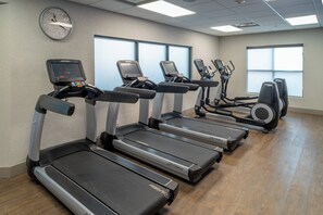 A gym with treadmills, ellipticals, and a digital clock on the wall. - Delta Hotels by Marriott Huntington Downtown (Huntington)