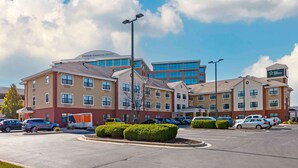 Un hôtel composé de plusieurs bâtiments, un parking et un ciel dégagé.