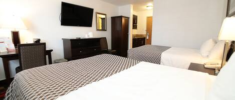 A hotel room with two beds, a desk, a chair, a TV, a mirror, and a wardrobe.