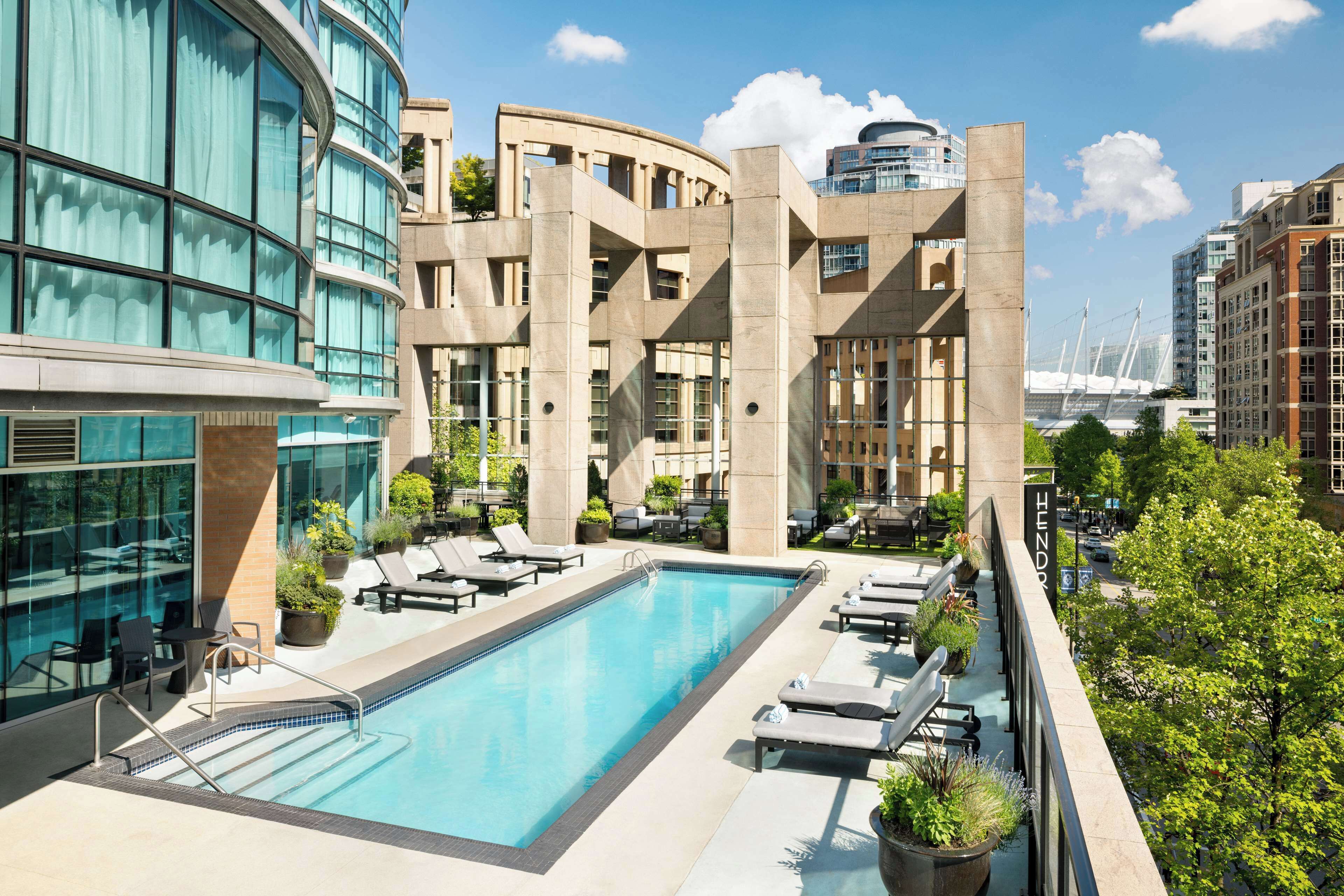 Una piscina al aire libre, sillones reclinables de piscina