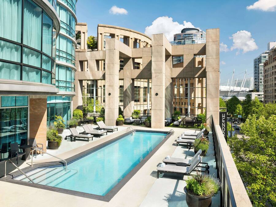 Una piscina al aire libre, sillones reclinables de piscina