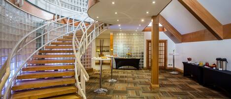 A spacious interior with a wooden staircase, a dining area, and a kitchen.