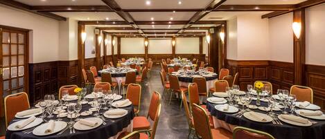 A banquet hall with round tables set for dining, equipped with chairs and table settings.