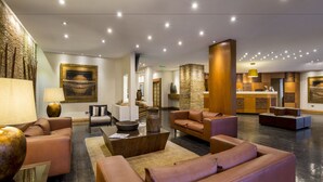 Un hall espacioso con sofás de cuero, un mostrador de recepción y un jarrón grande.
