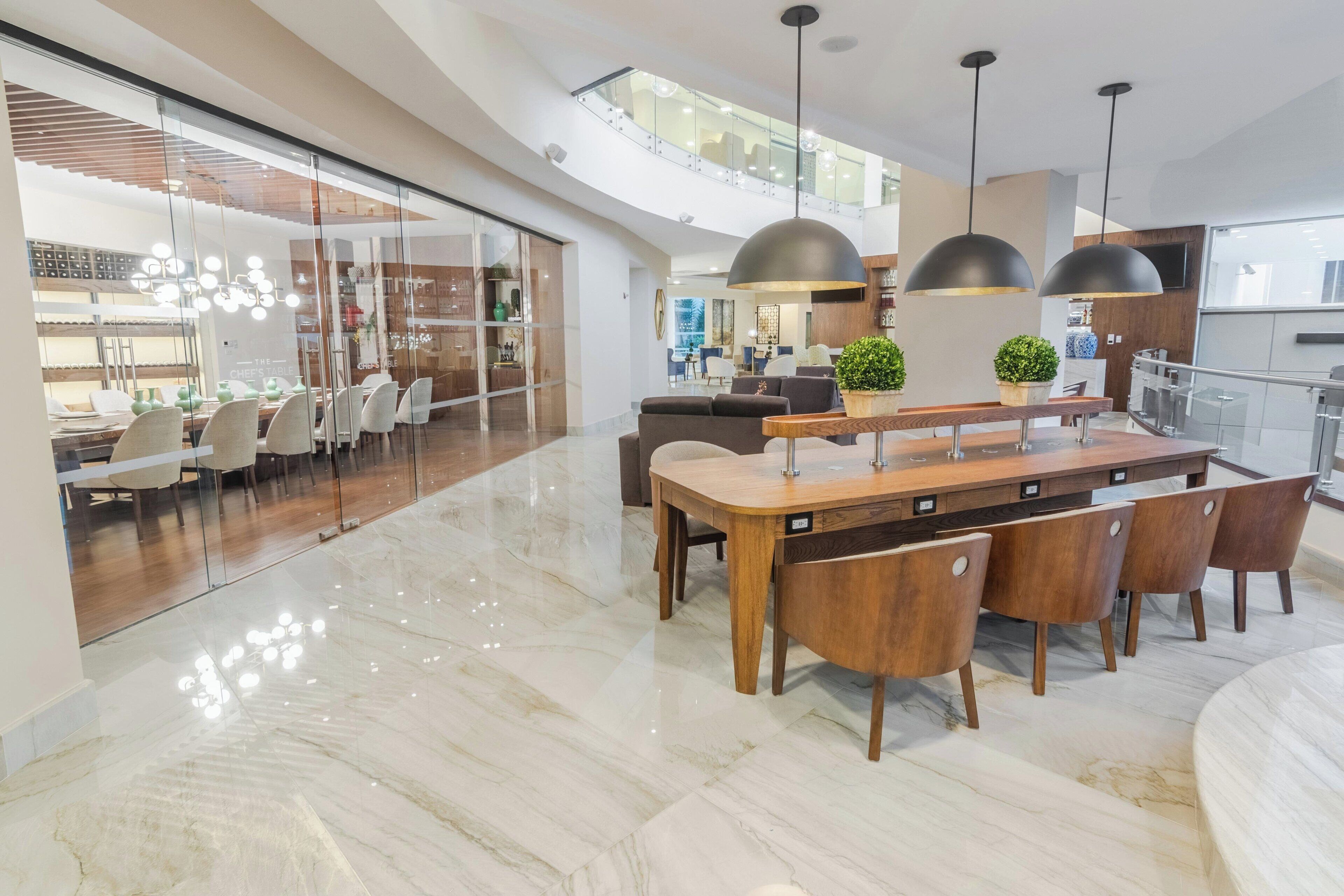 Una cocina moderna con una isla central, sillas de madera e iluminación colgante.