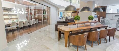 Una cocina moderna con una isla central, sillas de madera e iluminación colgante.