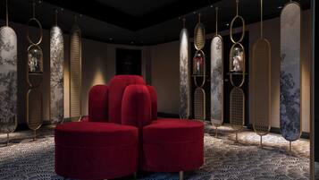 A modern interior with a red upholstered seating area, patterned floor, and decorative panels with embedded lights.