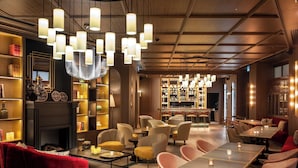 A modern interior with a bar area, seating arrangements, and a fireplace. - Maison Rouge Strasbourg Hotel&Spa, Autograph Collection (Strasbourg)