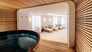 A modern spa area with a wooden slatted ceiling, a hot tub, and a seating area with lounge chairs and a sofa. - Maison Rouge Strasbourg Hotel&Spa, Autograph Collection (Strasbourg)