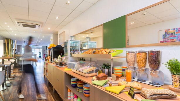 A buffet area with various food items and a counter with napkins and condiments.