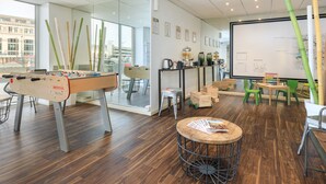 A modern office space with a foosball table, a whiteboard, and a large window offering a city view.