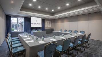 A conference room at Talbot Hotel Stillorgan with a long table, chairs, and a presentation screen.