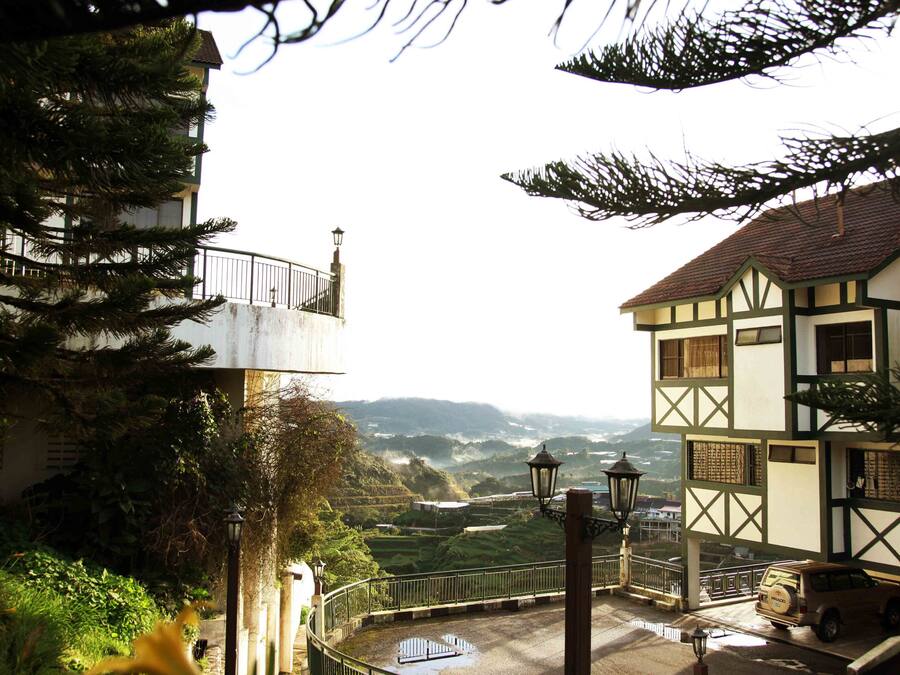 A traditional building with a balcony overlooking a scenic landscape.