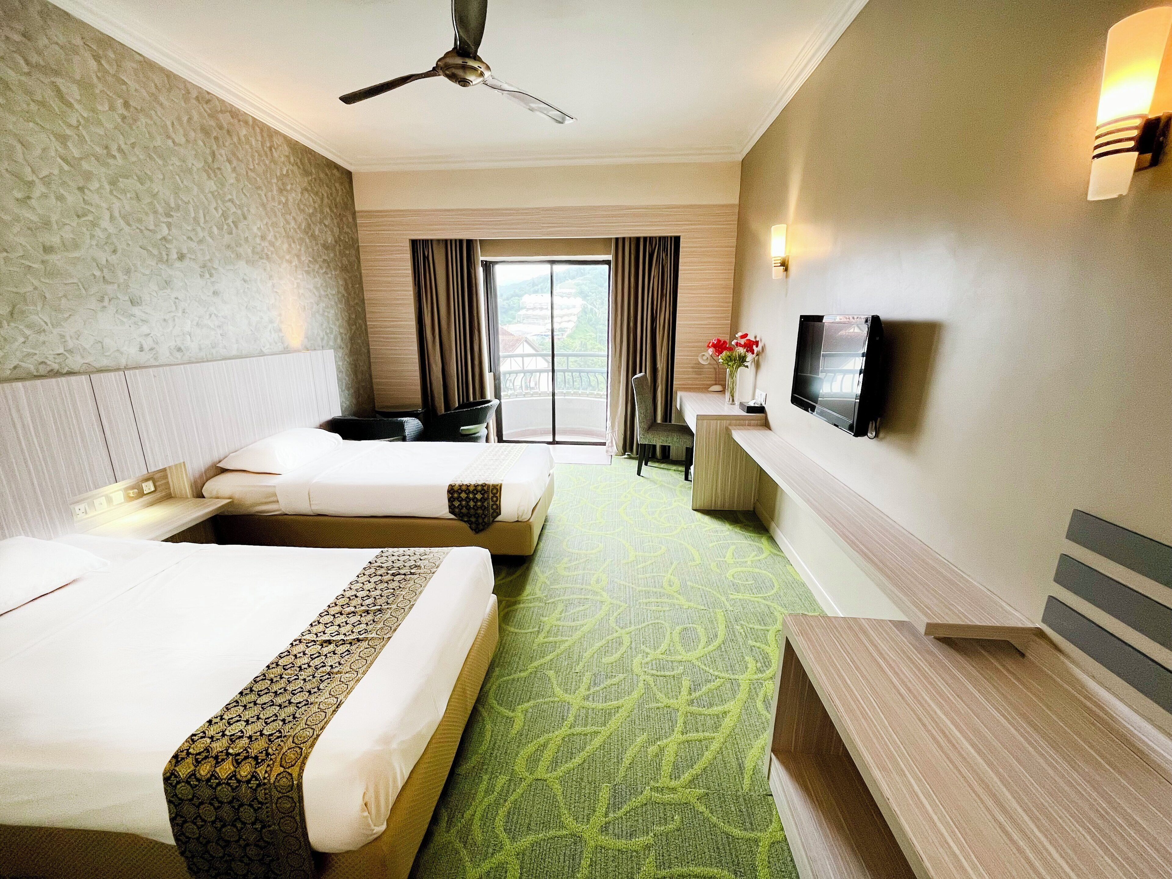 A hotel room with two beds, a desk, a chair, a television, and a balcony view.