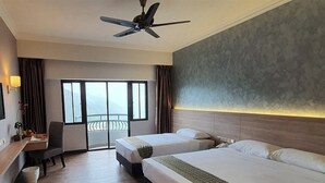 A hotel room with two beds, a desk, a chair, a ceiling fan, and a view of the outdoors. - Copthorne Hotel Cameron Highlands (Brinchang)