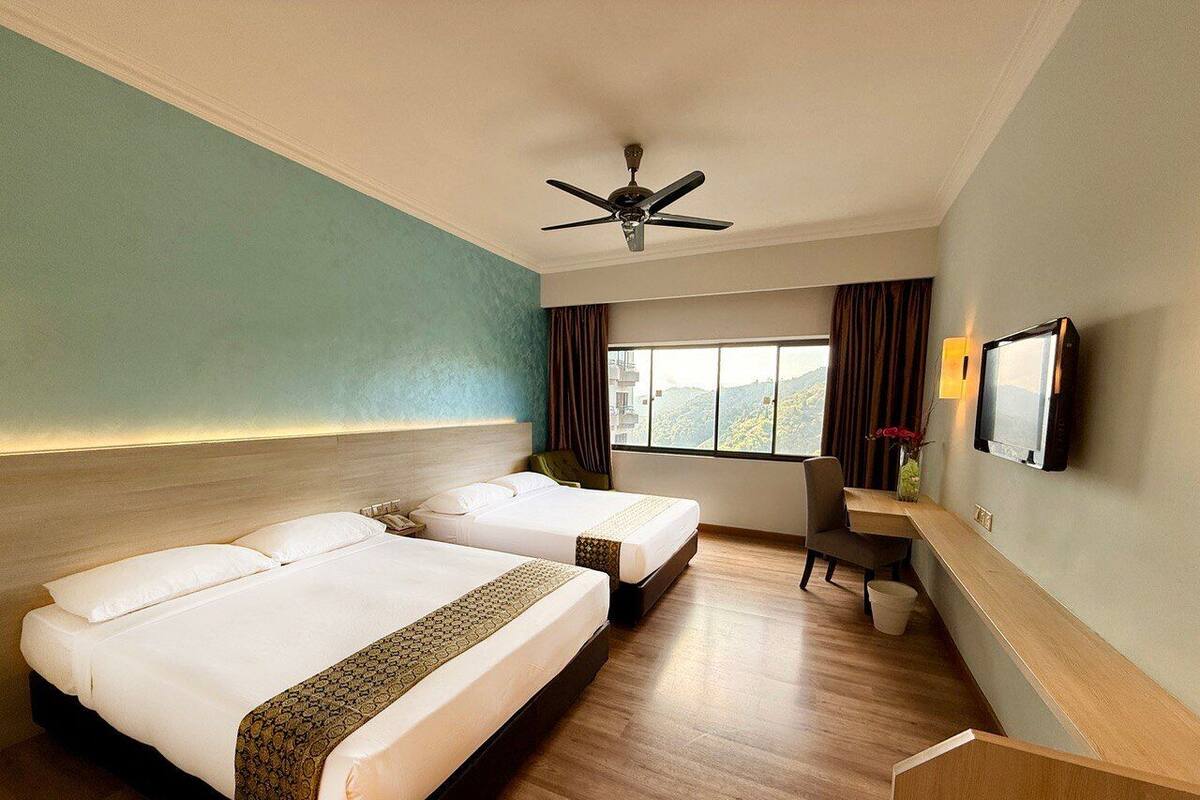 A hotel room with two beds, a desk, a chair, a TV, and a window with a view.
