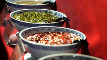 A row of bowls with different sauces on a table.