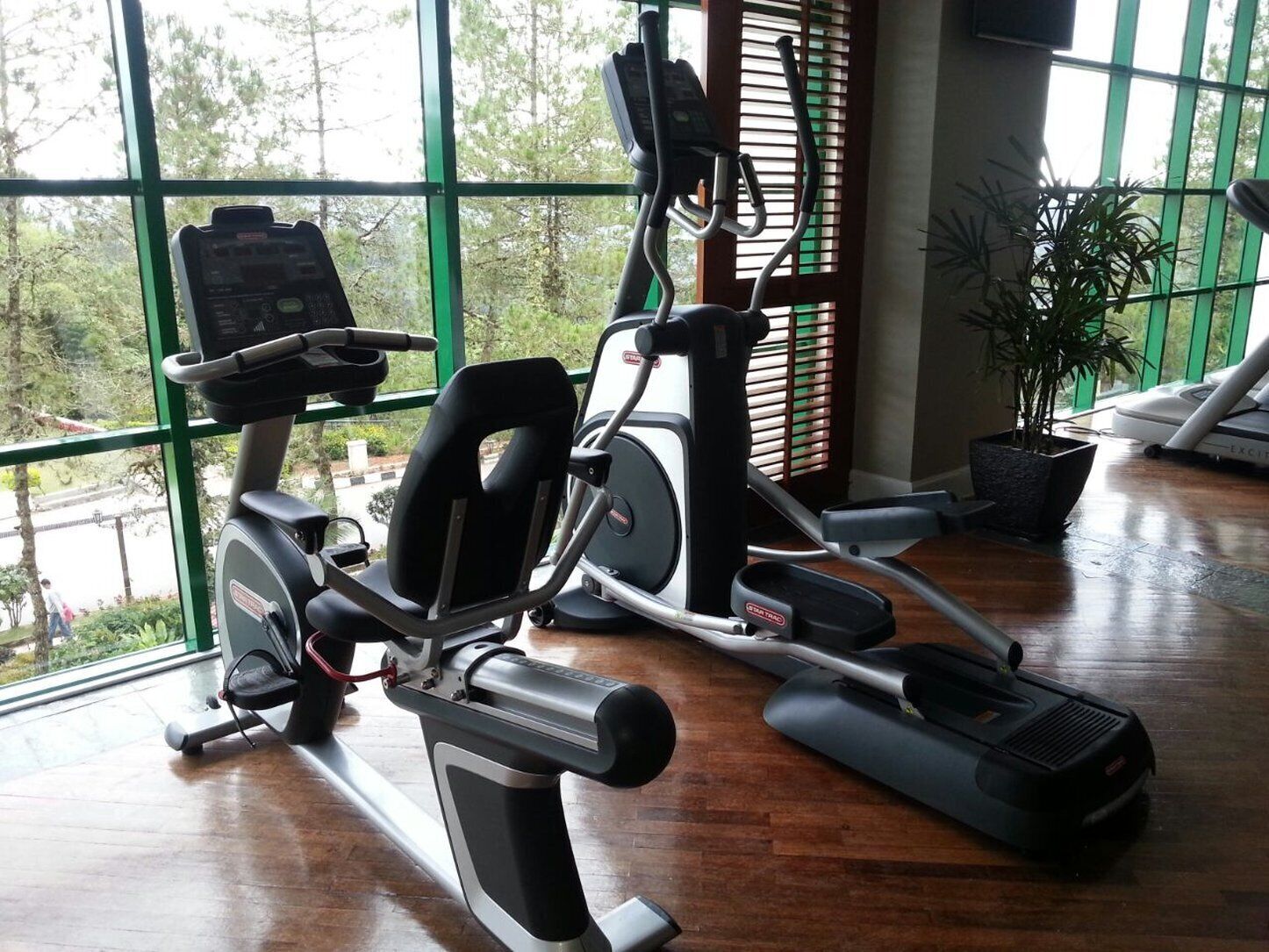 A home gym with an elliptical machine, a treadmill, and a stationary bike.