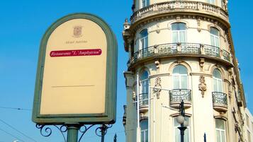 A historic building with a dome and ornate balconies, featuring a sign for "Hotel Asorta" and "Restaurant L. Amphitryon".