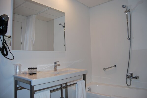 A bathroom with a sink, mirror, and shower. - Estudiotel Alicante (Alicante)