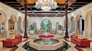 A spacious lobby with a central fountain, elegant chandeliers, and comfortable seating areas.