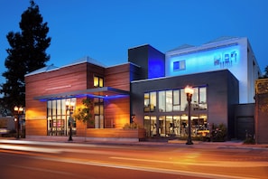 A modern hotel with a prominent 'HOTEL' sign, large windows, and a well-lit facade. - Aloft by Marriott Sunnyvale (Sunnyvale)