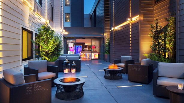 Eine Terrasse im Freien mit moderner Möbel, Feuerstellen und stimmungsvoller Beleuchtung.