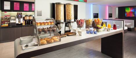 A breakfast buffet with various food items and a coffee station.