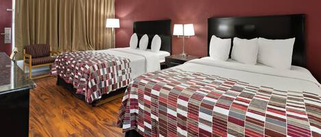 Une chambre d’hôtel avec deux lits, un bureau, une chaise et une grande fenêtre avec des rideaux.