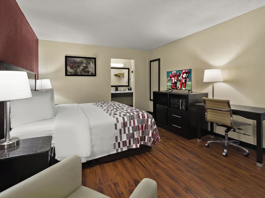 Une chambre d’hôtel équipée d’un lit, d’un bureau, d’une chaise et d’un téléviseur.