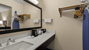 Een badkamer met een grote spiegel, twee wasbakken, een handdoekrek en een houten vloer.