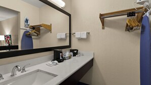 Un baño de hotel con un espejo grande, un lavabo y un perchero para toallas.