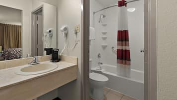 Un baño con lavabo, espejo, secador de pelo y ducha.