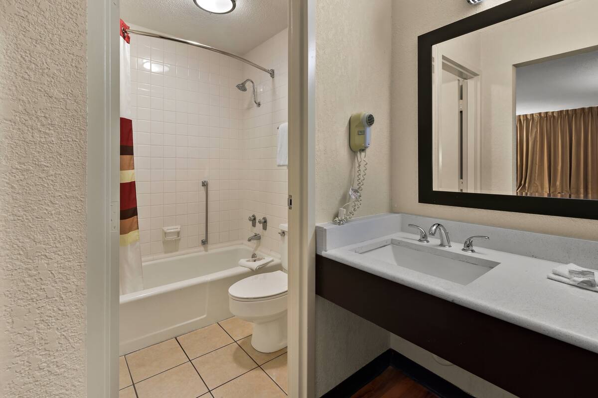 Een badkamer met een bad, toilet en wastafel.