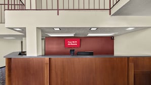 Una mesa de recepción con un letrero que indica disponibilidad de Wi-Fi gratuito en todas las habitaciones.