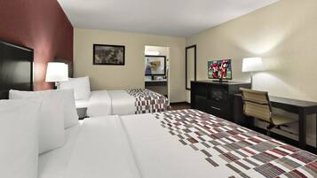 Habitación de hotel con dos camas, un escritorio, una silla, un televisor y un espejo.