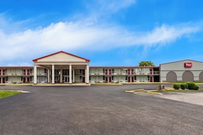 A motel with a central building featuring a covered entrance and multiple balconies. - Red Roof Inn & Suites Cave City (Cave City)